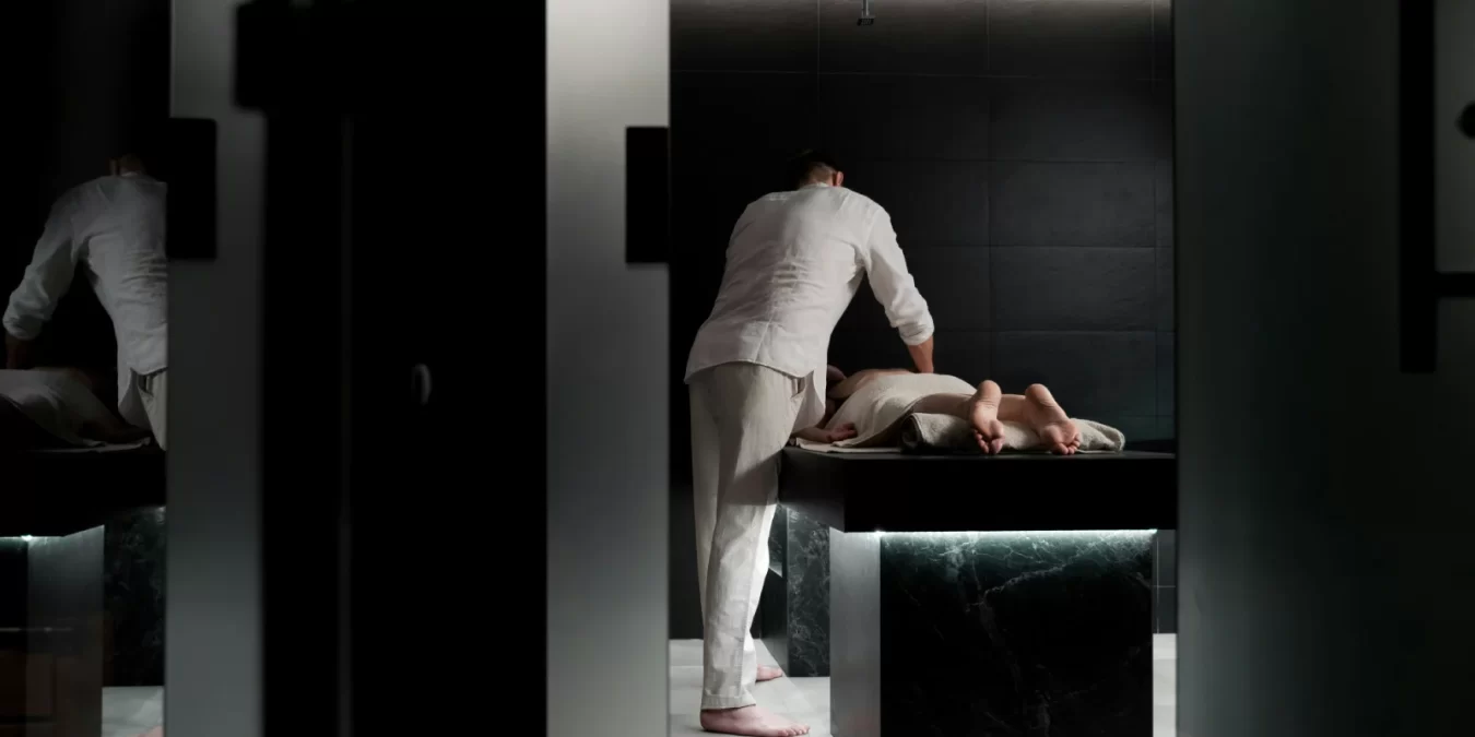 Masajista profesional realizando un tratamiento en un spa moderno, enfocado en la relajación y el bienestar del cliente.